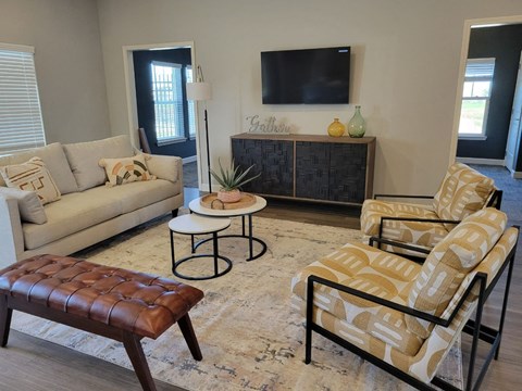 a living room with a couch and chairs and a television